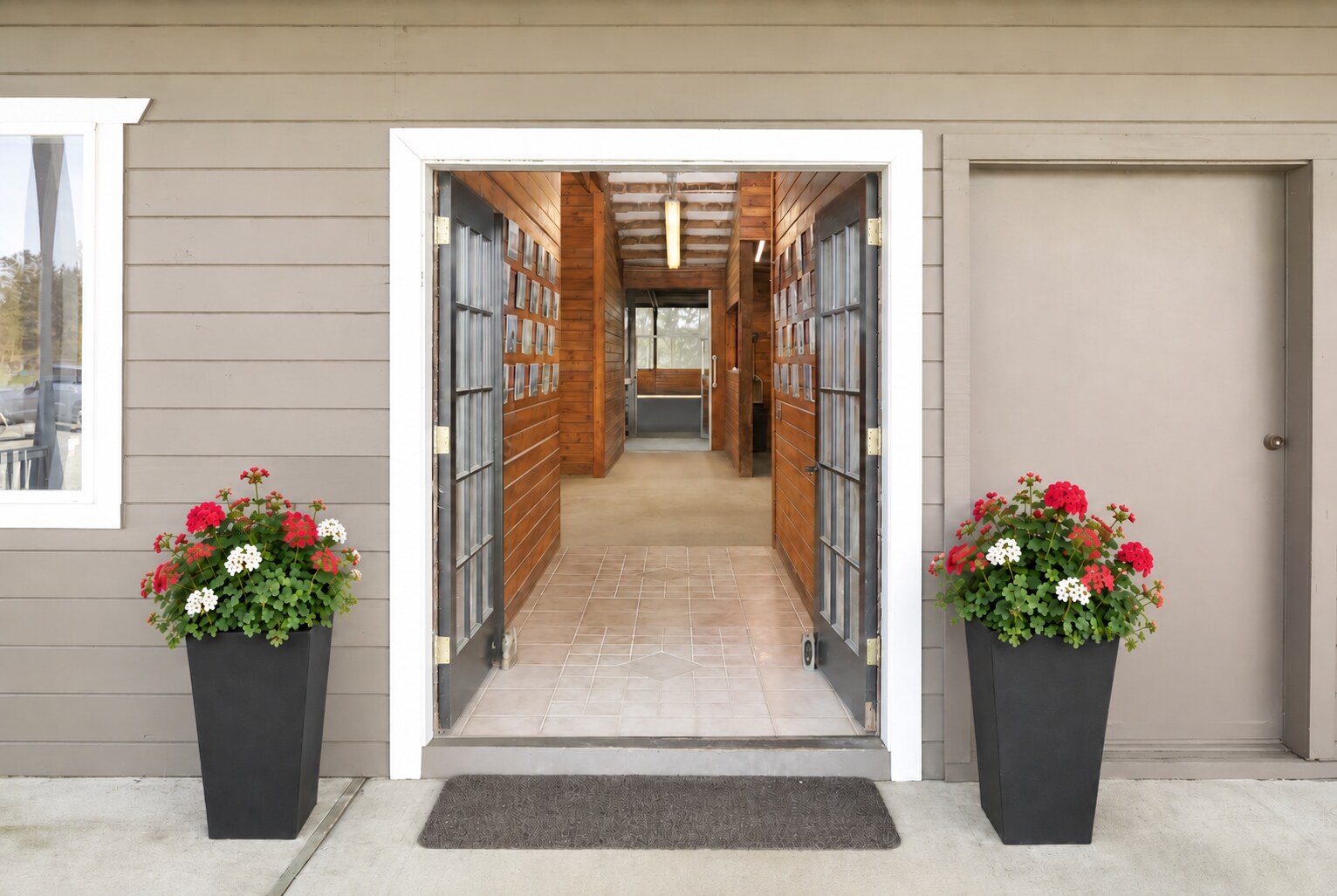 Open barn doors leading into a warm, wood-paneled aisle at the new Seven Hills Training facility in Monroe, WA.